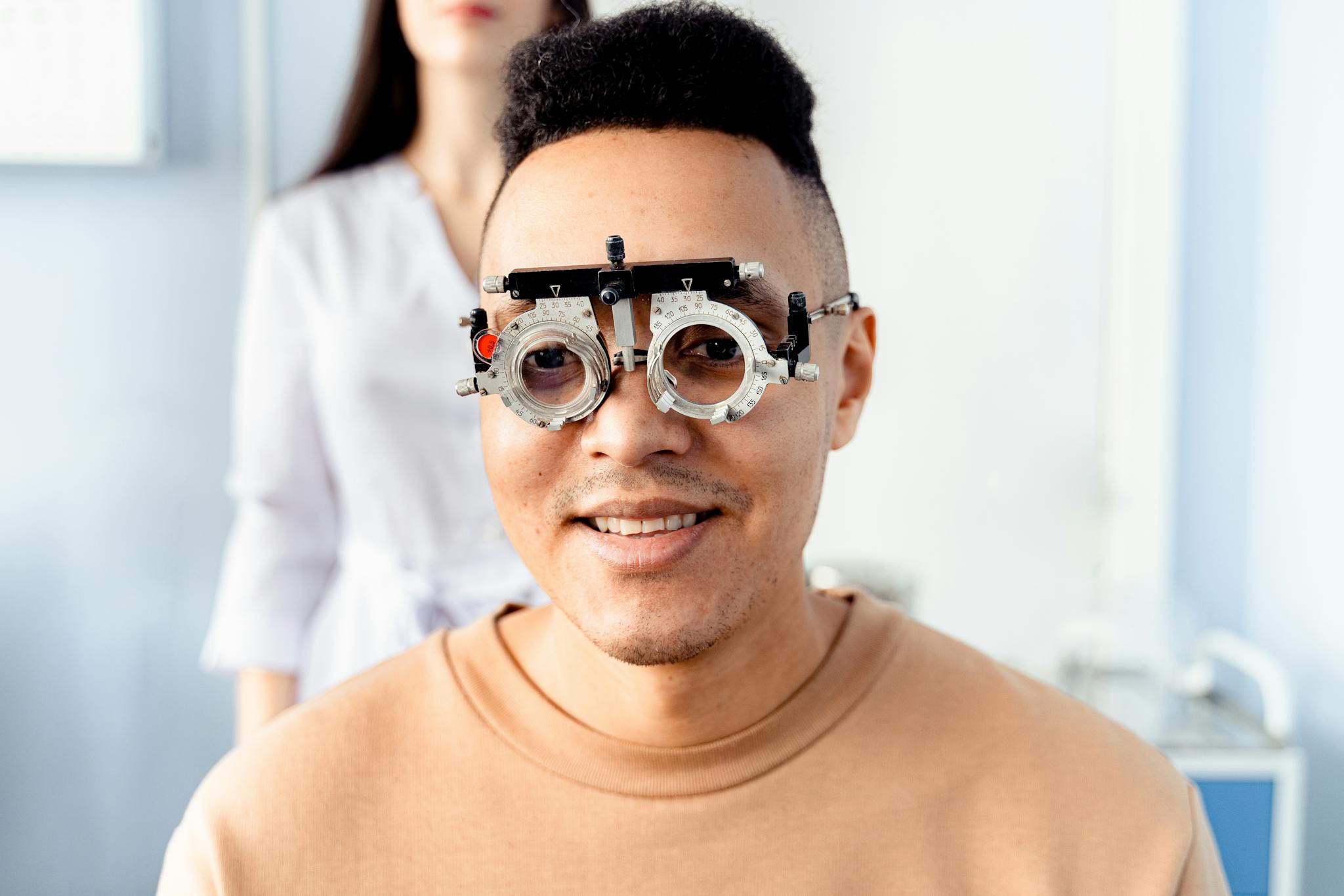 Male patient having an eye examination with a trial frame at the optometrist's office.