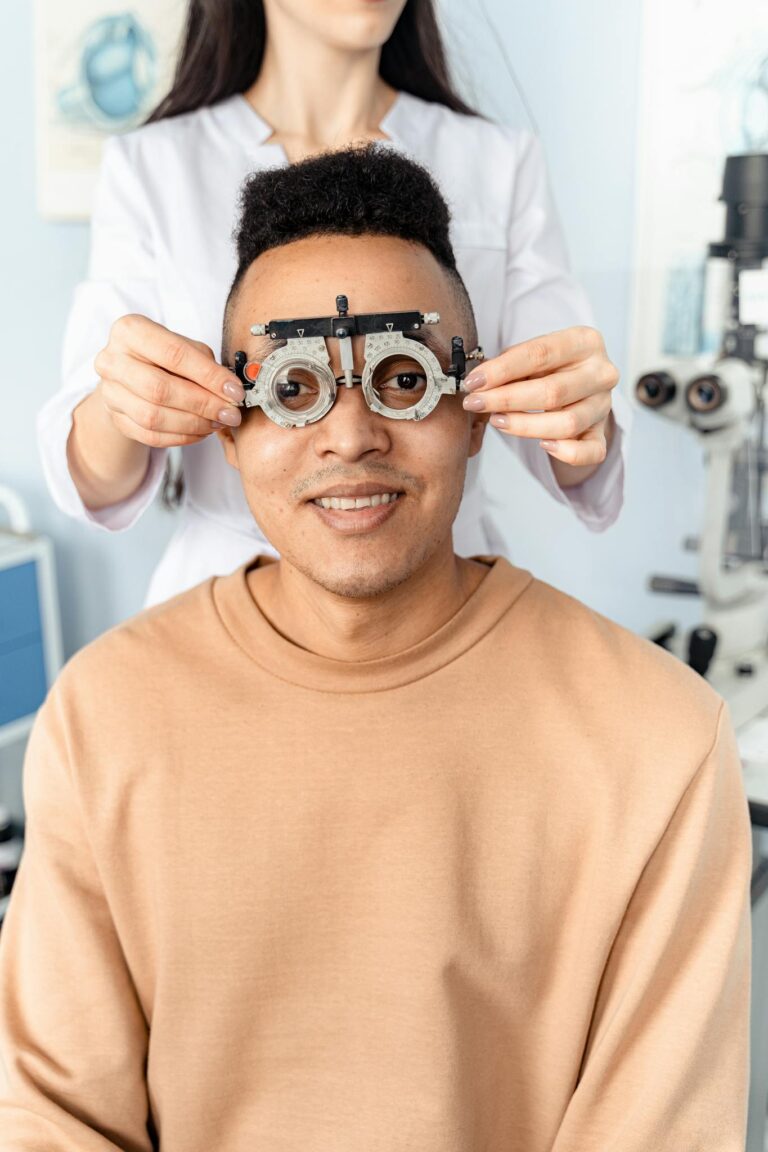 Optometrist assisting patient with an optical trial lens frame for an eye examination.