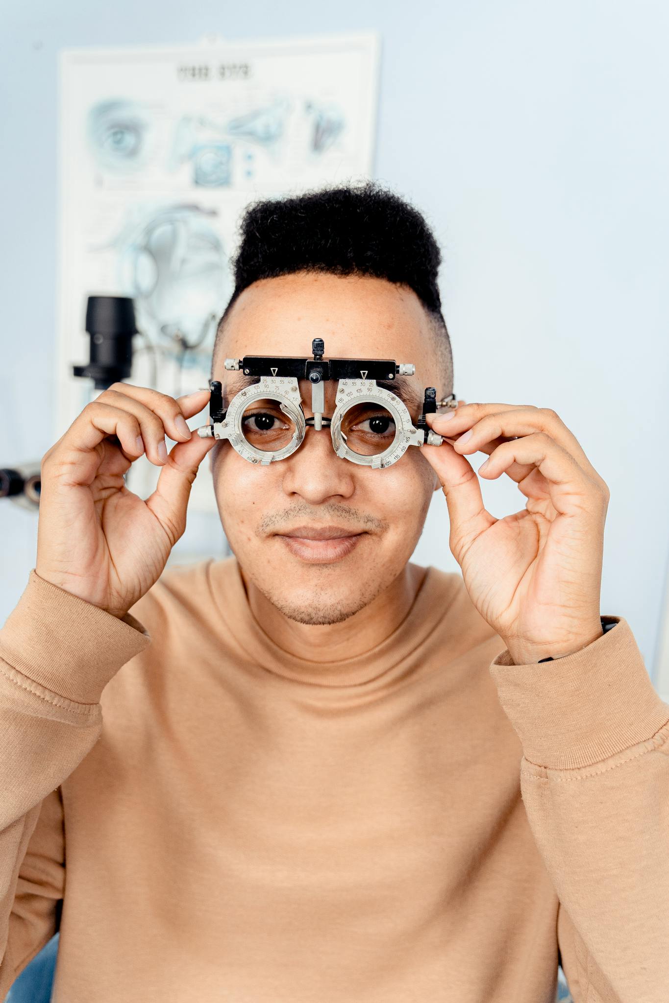 Smiling man holding trial frame in an optometrist clinic for eye examination.